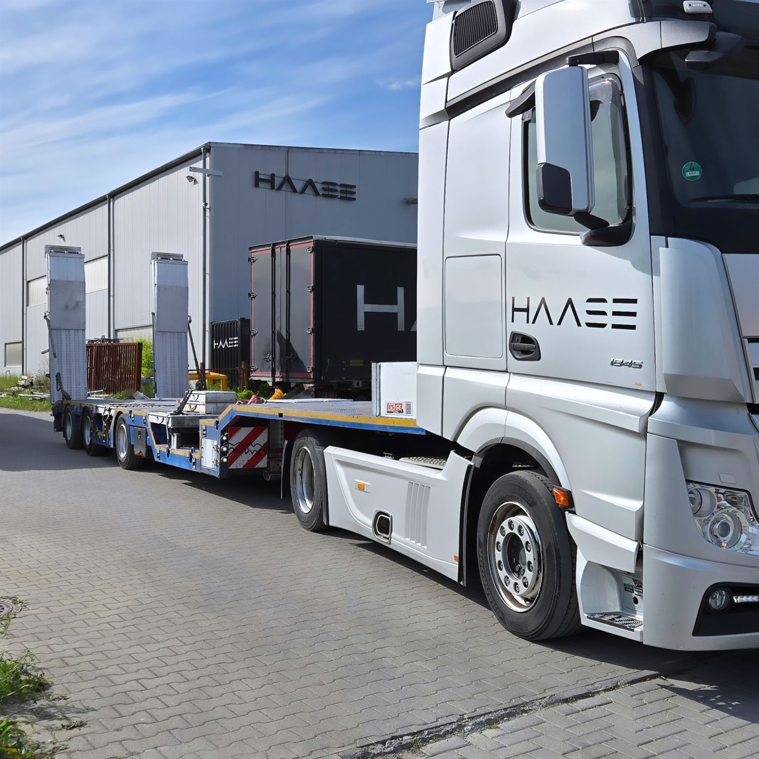 HAASE Sattelzug mit Tieflader vor der Halle